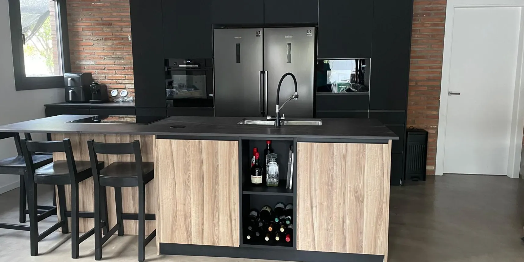 Cocina abierta terminada con isla, pared de ladrillo visto y suelo continuo