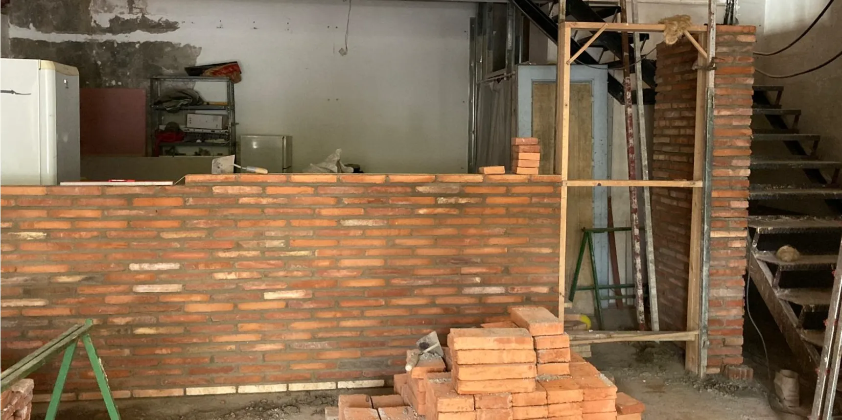 Interior en obra con tabique de ladrillo visto a medio levantar