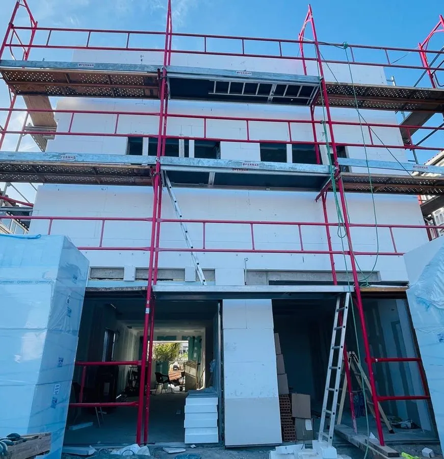 Edificio en rehabilitación con andamios y aislamiento en fachada